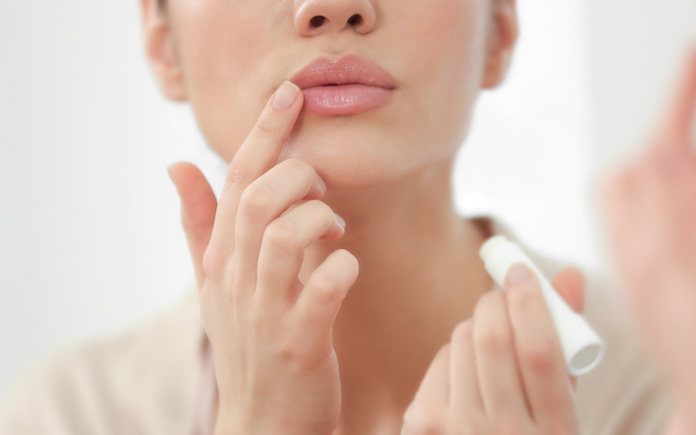 Persona aplicando bálsamo labial sobre labios con aspecto saludable, como parte del cuidado diario para mantener la barrera cutánea protegida