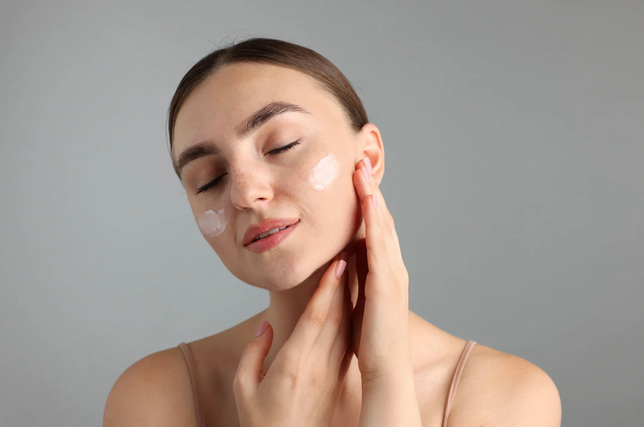 mujer aplicando crema hidratante en piel sensible del rostro